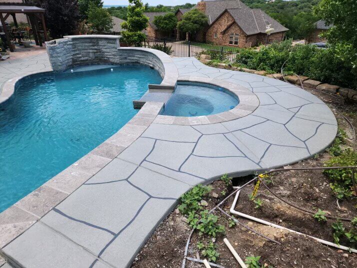 Recently remodel pool with water feature, hot tub, and stone walkway.