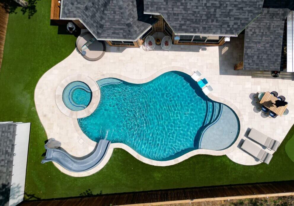 Custom pool with hot tub and slide in pristine condition after Emerald Pool Care pool services.