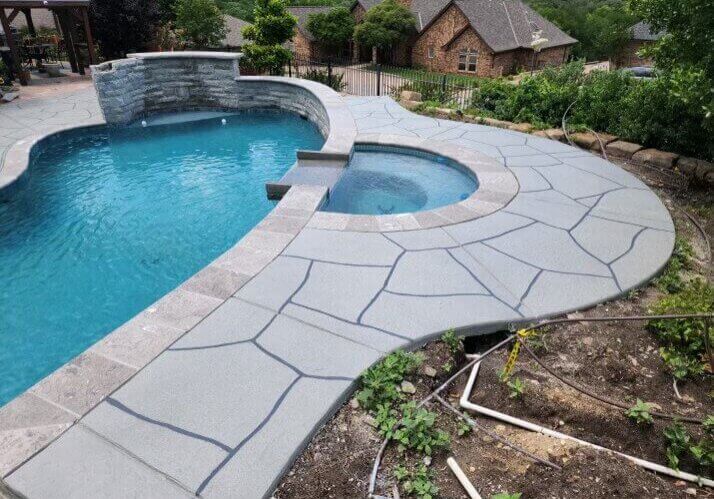 Recently remodel pool with water feature, hot tub, and stone walkway.